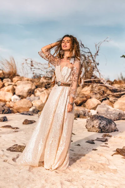 Красивая молодая женщина в платье на пляже на закате — стоковое фото