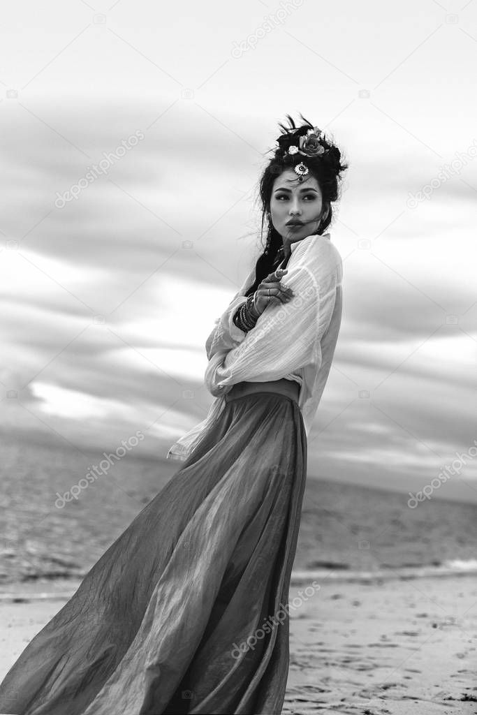 oriental stylish boho girl on the beach at sunset