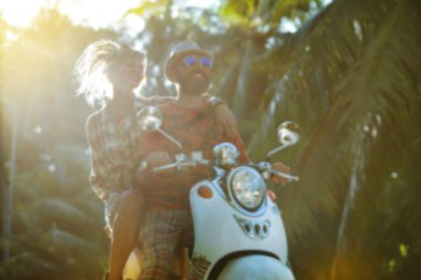 Parkta motosiklet süren iki genç insan.