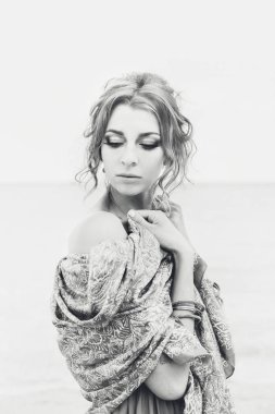 Güzel, çekici bir kadın sahilde kameraya poz veriyor.