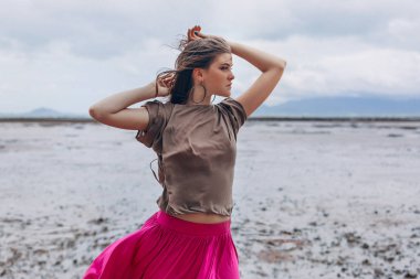 Sahilde poz veren güzel genç bir kadın.