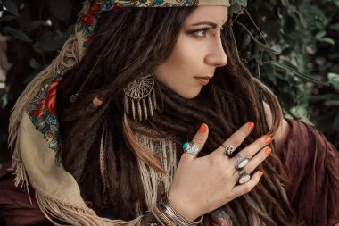 portrait of young tender bohemian style woman posing in garden