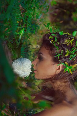 çekici genç bir kadın tropik arka planda poz veriyor.