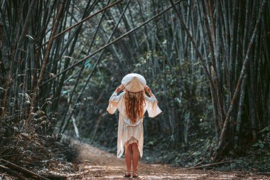 Bambu ormanında şapkalı çekici bir genç kız.