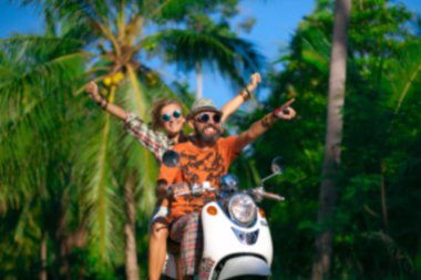 Tropik plajda motosiklet süren bikinili genç bir kadın.