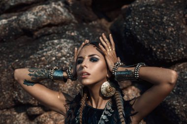 Doğada kabile konseptinde poz veren güzel bir kadın.