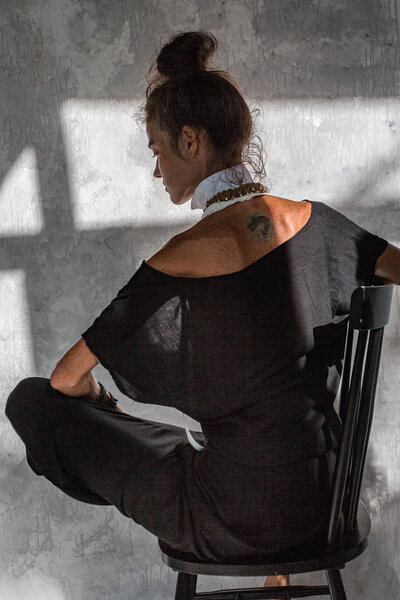 young fashion woman in black dress posing on simple background