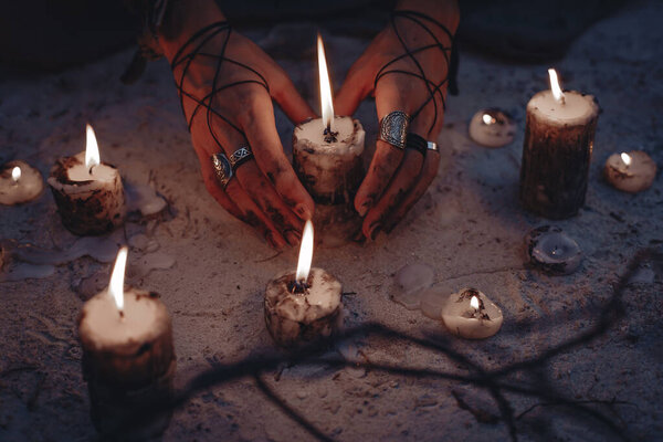 cropped of magic woman in forest with candles