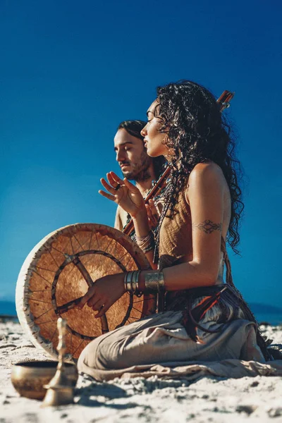 Vackra unga par spelar etnisk musik med shaman trummor — Stockfoto