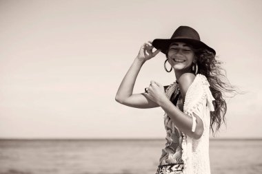 Şapkalı genç bohem kız kameraya poz veriyor, moda çekimi.