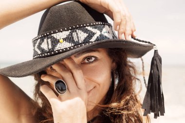 Şapkalı genç bohem kız kameraya poz veriyor, moda çekimi.