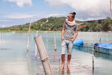 Yakışıklı genç adam açık havada kot şortlu