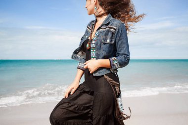 Güzel boho tarzı kadın sahilde poz veriyor.