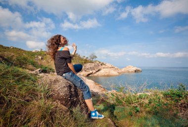 Doğada poz veren kot pantolonlu güzel bir kadın.
