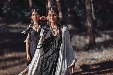 Ormanda birlikte poz veren iki bohem kadın.