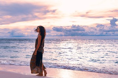 attractive bohemian woman traveler posing on ocean beach