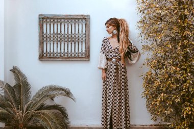 Bohem tarzında bir kadın eski moda pozlar veriyor.