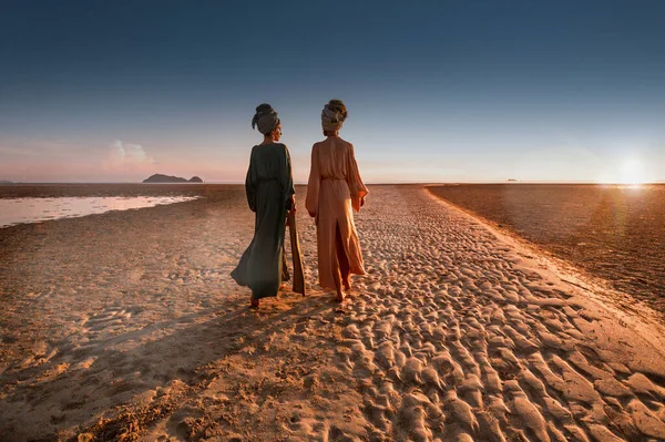 Gün batımında sahilde türbanlı iki genç güzel kız — Stok fotoğraf