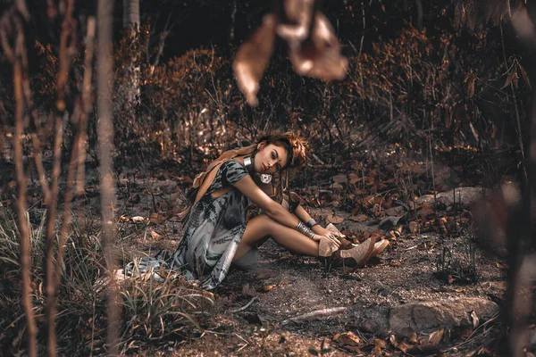 Młoda kobieta w stylu boho siedzi na ziemi na zewnątrz — Zdjęcie stockowe