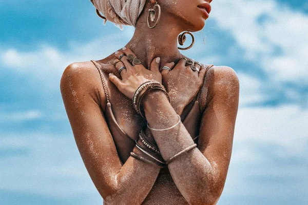 Sarıklı kadın sahilde poz veriyor.