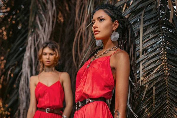 Twee mooie jonge modieuze modellen in rode jurken buitenshuis — Stockfoto