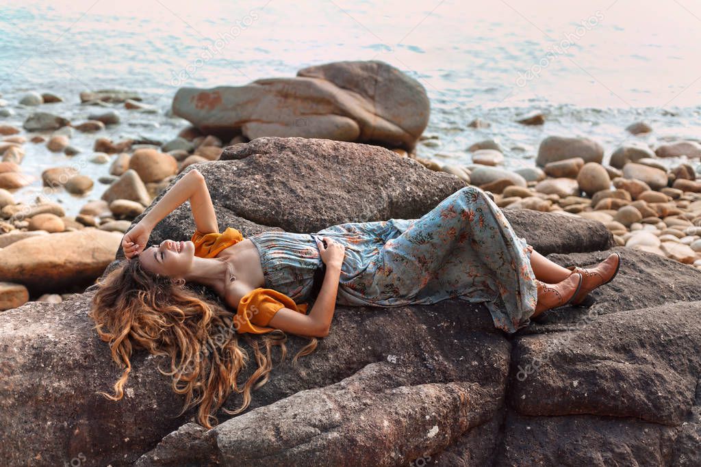 attractive boho girl posing on beautiful stone beach
