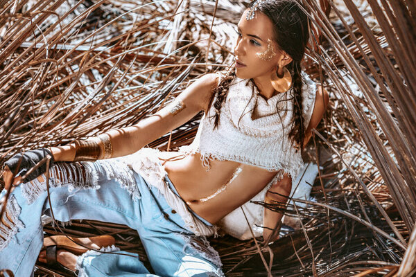 красивая молодая стильная женщина на фоне сухих пальмовых листьев
