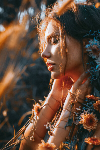 close up portrait of young and tender woman on a field at sunset
