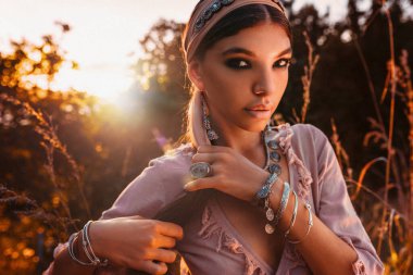 Gün batımında sahada giyinmiş güzel, genç ve şık bir kadın.