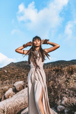 Gün batımında zarif elbiseli güzel, genç bir bayan.