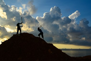Yığın toprak kazmak için çapa kullanarak işçi