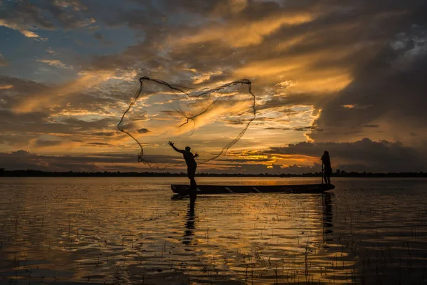 Pescador está pescando usando rede de pesca no rio . — Fotografia de Stock