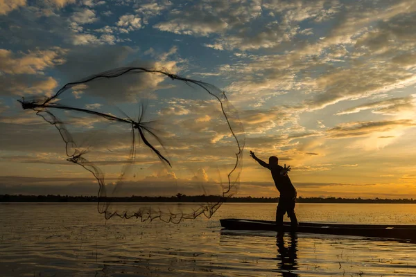 Pescatore pesca utilizzando la rete da pesca sul fiume . — Foto Stock