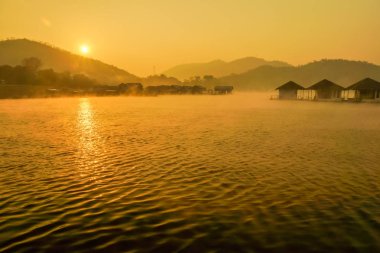 Gündoğumu ile Gölde yüzen kulübeleri