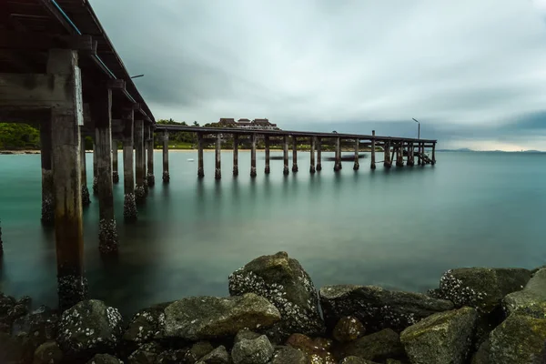 Puente de madera sobre mar sedoso con nubes de lluvia sedosas — Foto de Stock