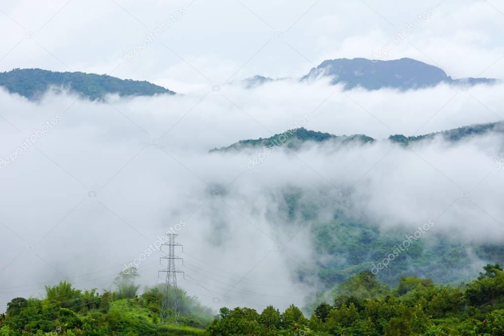 Electrical power transmission system  on hill covering with fog