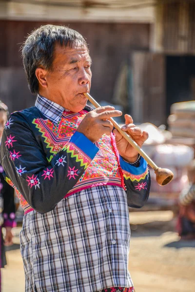 Hill tribù senior uomo che soffia tubo tradizionale, attrezzature musicali — Foto Stock