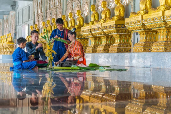 Pessoas fazendo oferendas de arroz na frente de fileiras de estátuas de monge — Fotografia de Stock