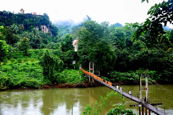 Ahşap köprü üzerinde yürüyen Budist rahipler kiliseye geri almak için