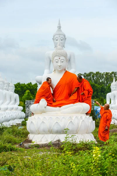 Monks dressing one of White Buddha Image with robes — Stock Photo, Image