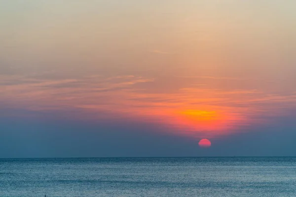 Mar calmo com céu laranja durante o pôr do sol — Fotografia de Stock