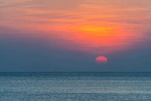 Mar calmo com céu laranja durante o pôr do sol — Fotografia de Stock