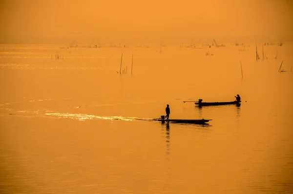 Silhouette fishermen on boat on river driving to fish — Stock Photo, Image