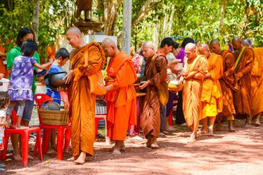 Budist rahipler için gıda ve şeyler sunan insanlar