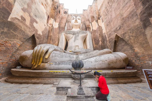 Camicia rossa donna rendendo rispetto alla più grande immagine di Buddha — Foto Stock