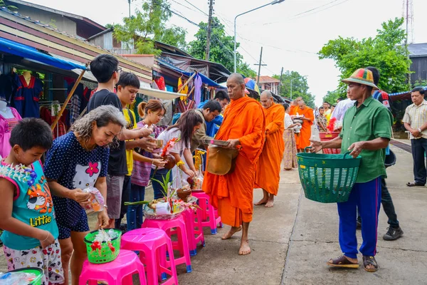 Gıda ve şeyler Budist rahipler grubuna sunan insanlar