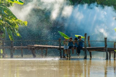Kırsal çocukların birlikte ahşap köprüde oturma grubu