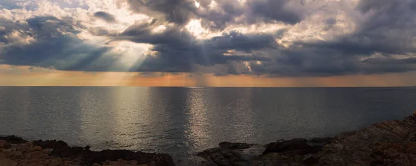 Rayo de sol a través del cielo pesado sobre el mar — Foto de Stock