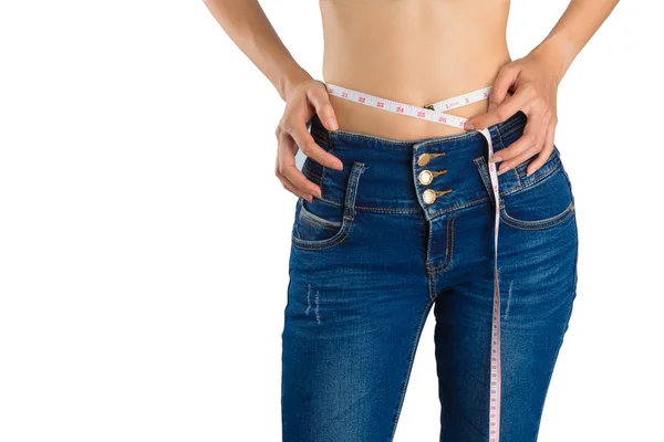 Flicka på vitt i blå jeans och måttband. — Stockfoto