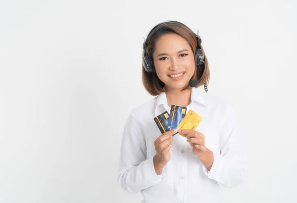 Centro de chamadas mulher com fone de ouvido segurando e cartão de crédito . — Fotografia de Stock